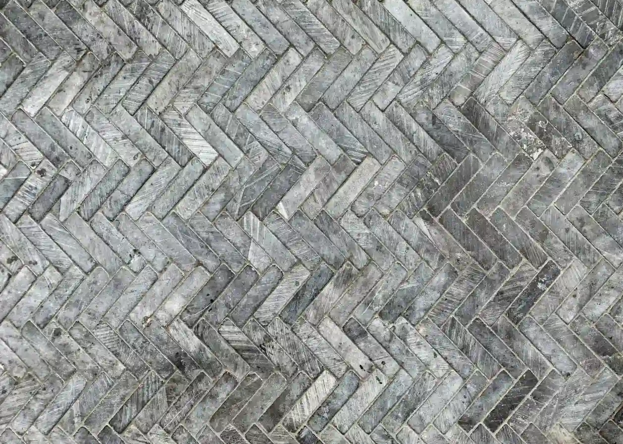 Weathered gray brick pavers laid in a herringbone pattern for an outdoor surface